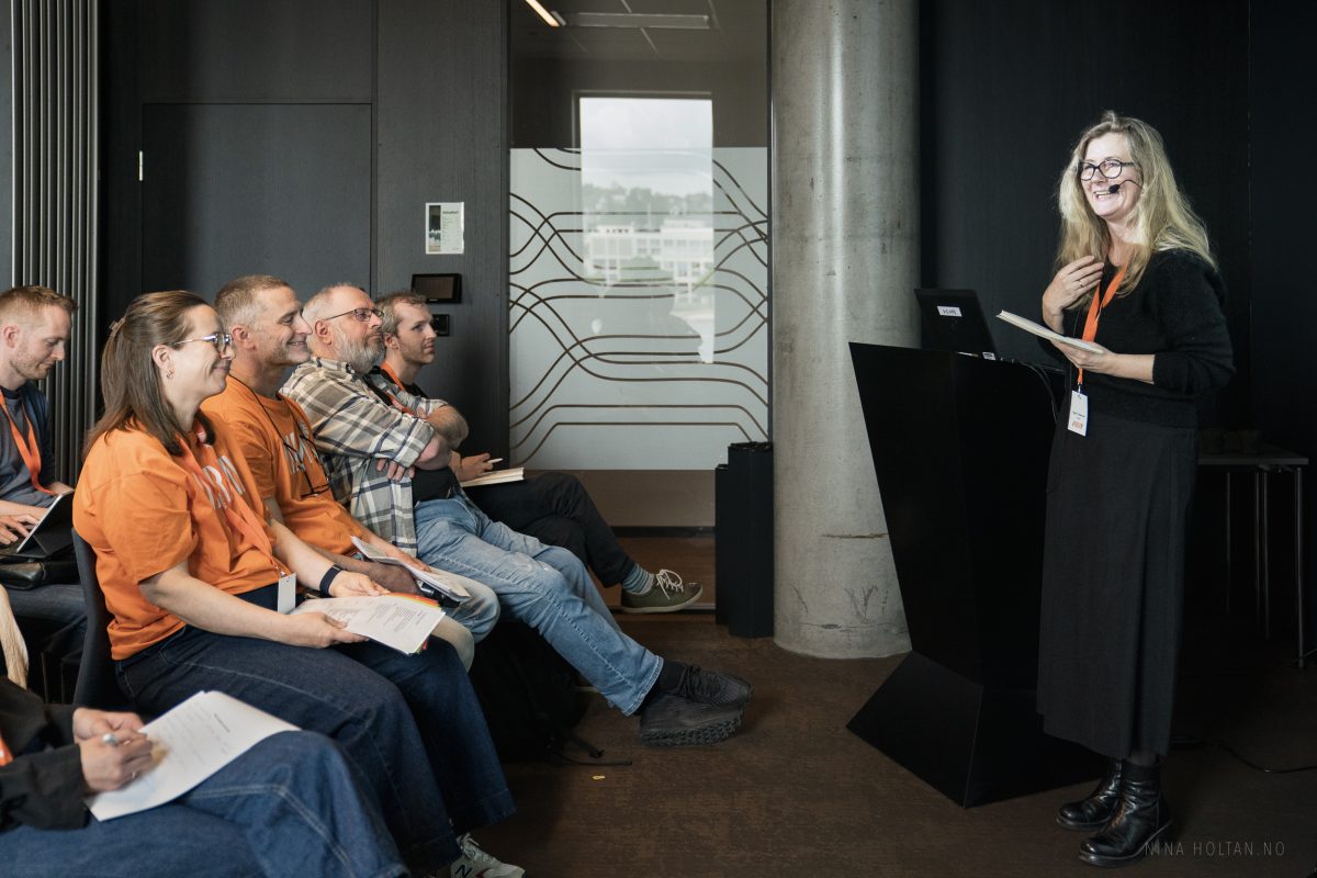 Illustrasjonsbilde av et foredrag under VIRAK-konferansen 2025. Bildet viser en foredragsholder og publikum.